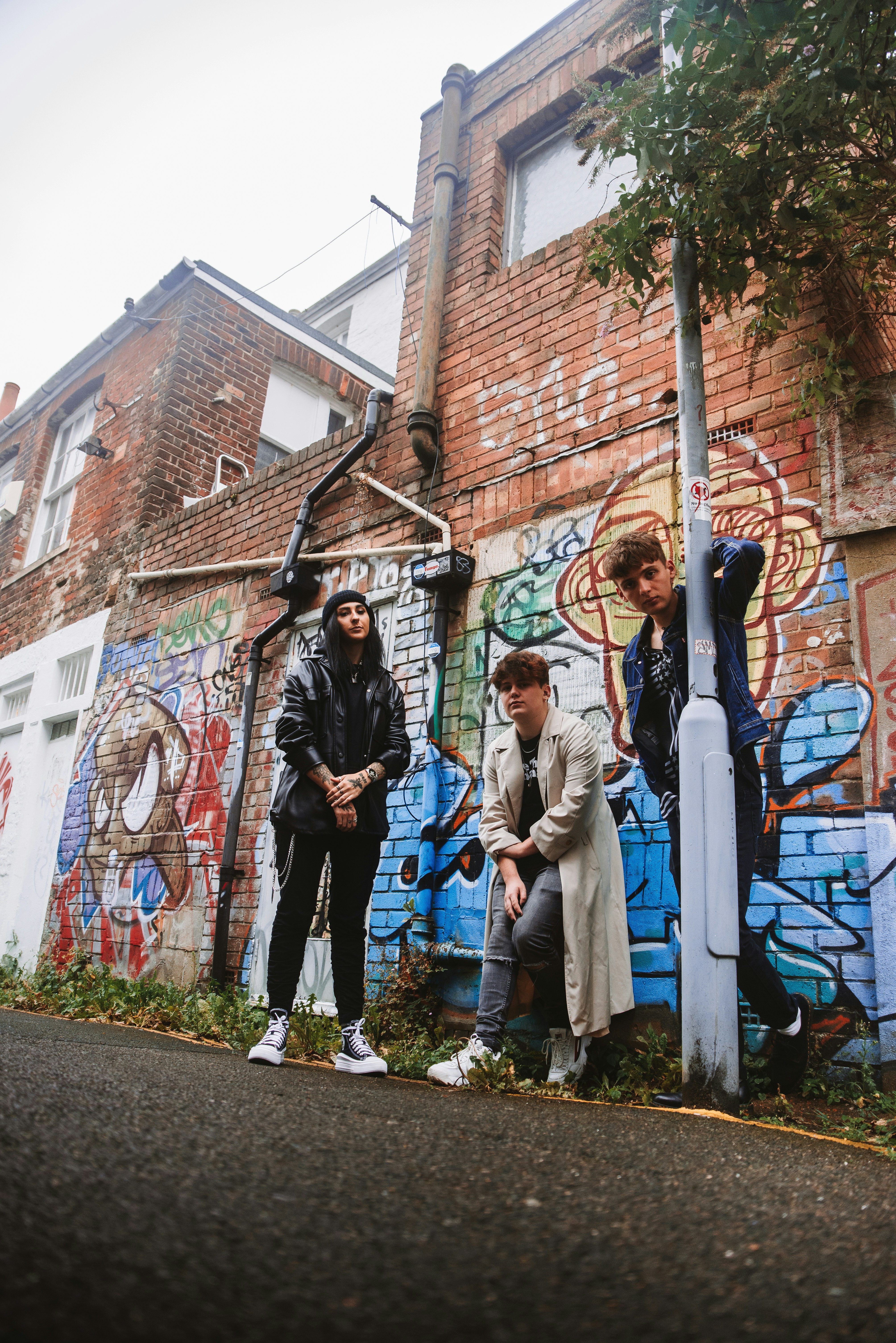 Group of friends posing against a graffiti wall