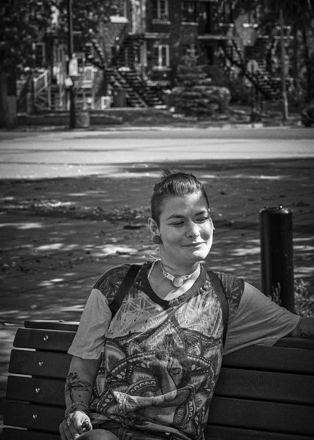 a black and white photo of a woman sitting on a bench