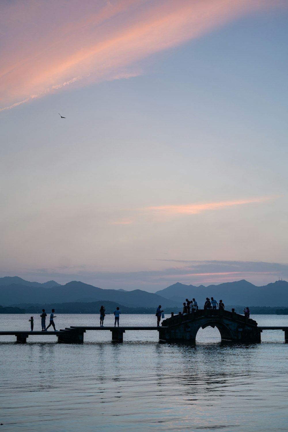 Un grupo de personas de pie en un puente sobre un cuerpo de agua