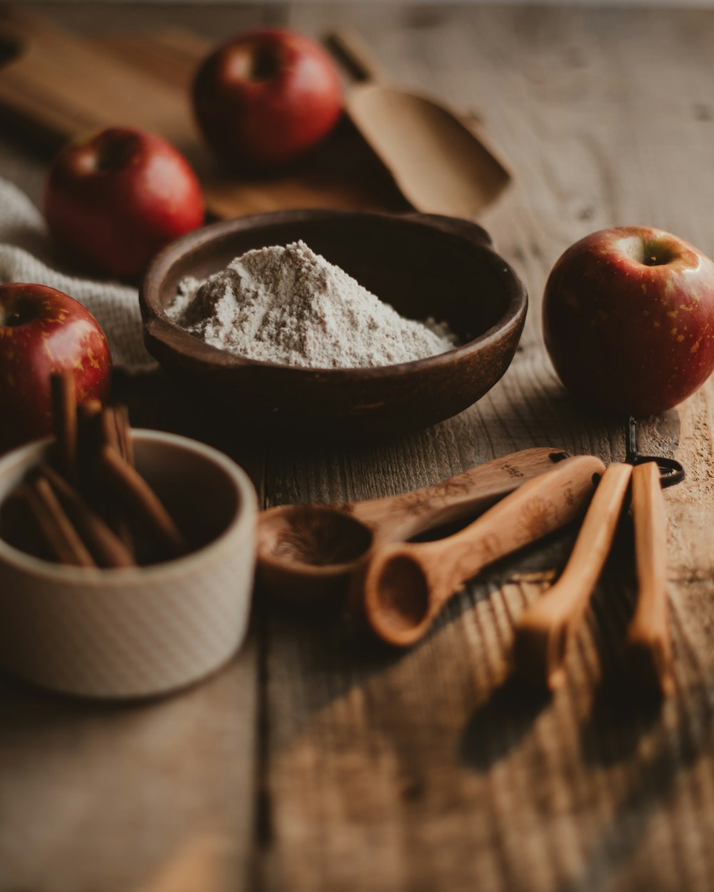 a wooden table topped with apples and cinnamon sticks