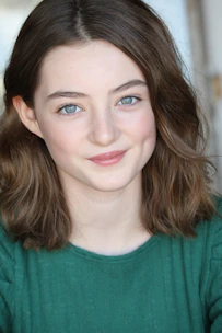 A friendly therapist smiling gently while speaking with a teenager.