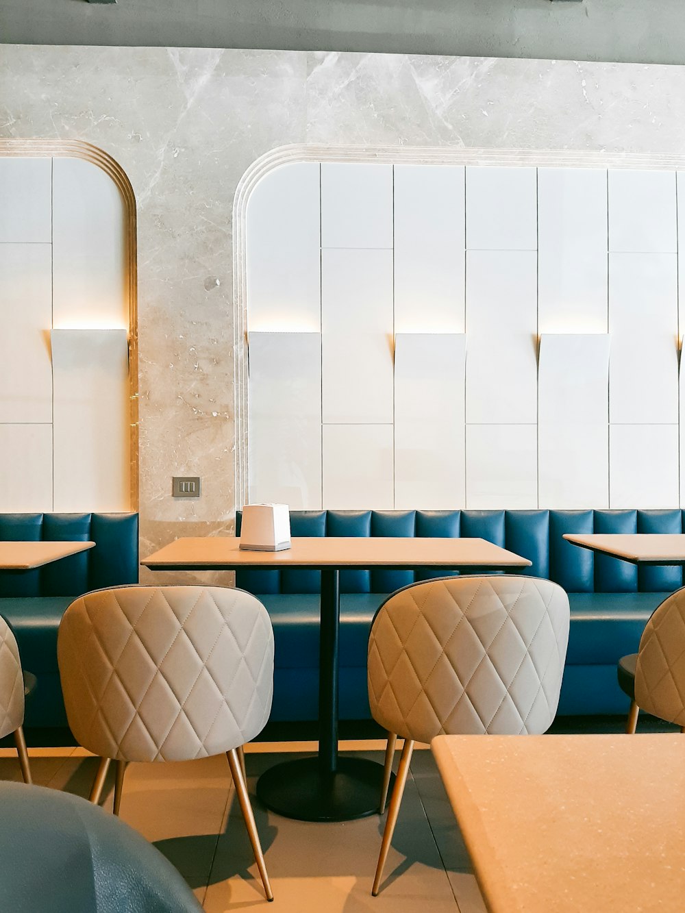 a restaurant with blue booths and tables and chairs