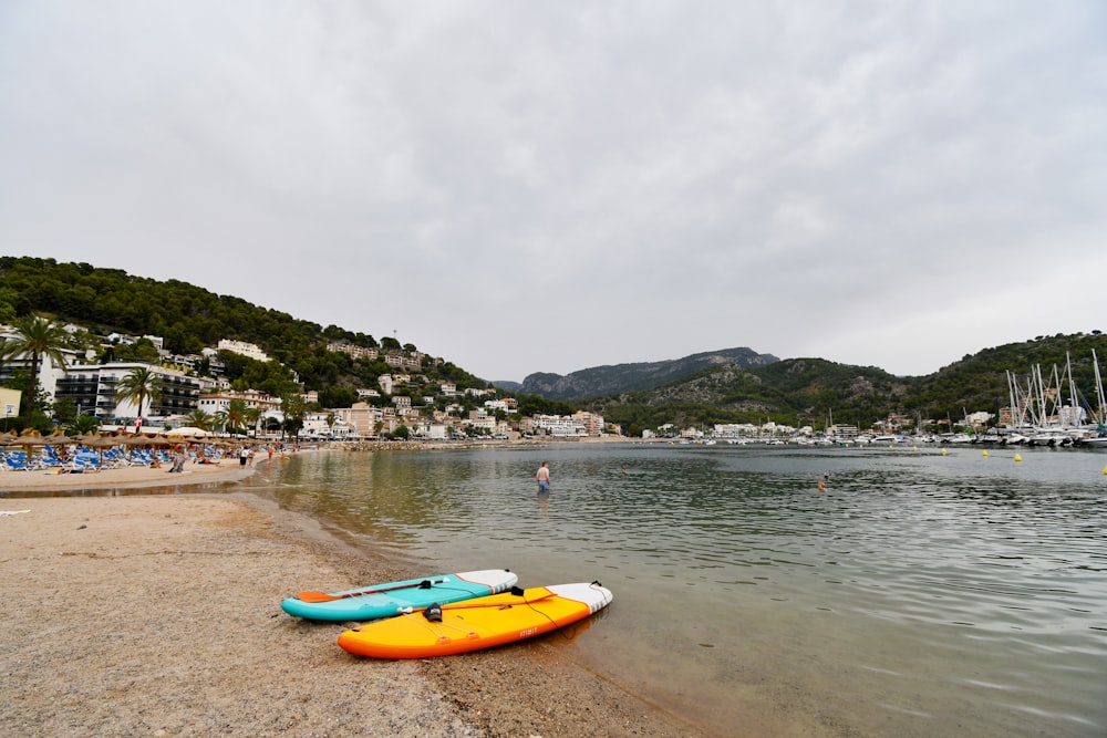 a couple of kayaks sitting on top of a sandy beach