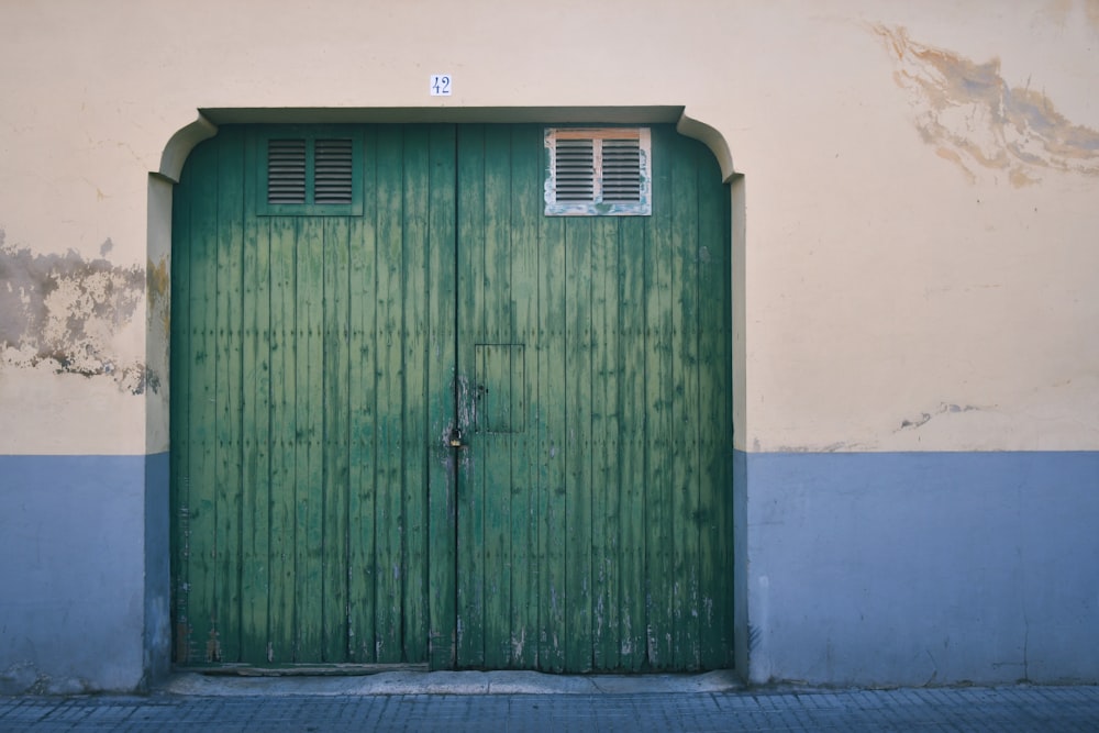 a green door with a window on the side of a building