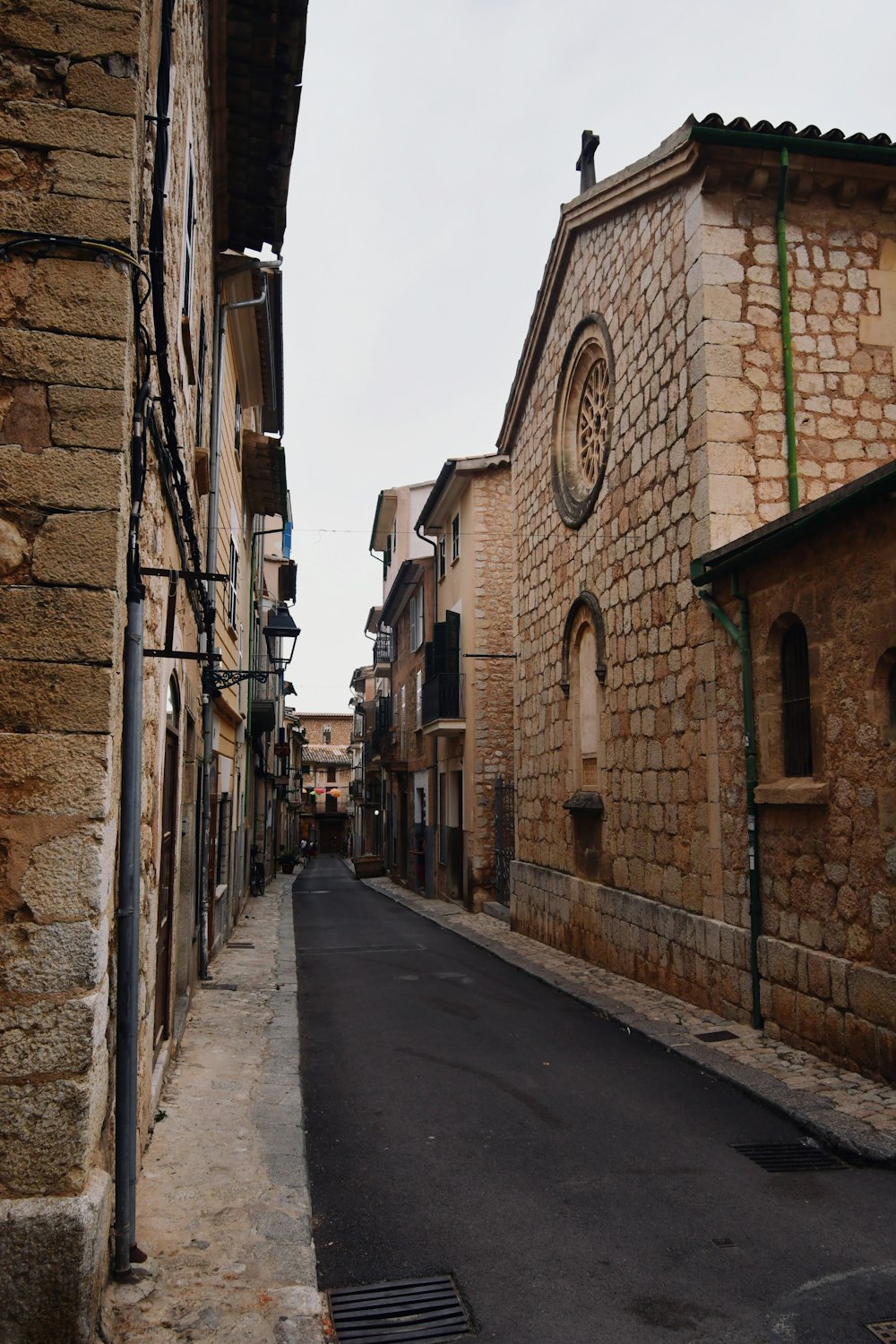 a narrow street with a church in the background