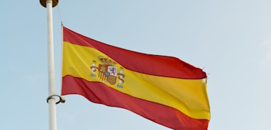 the spanish flag is flying high in the sky