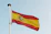 the spanish flag is flying high in the sky