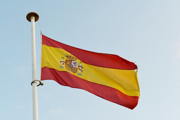 the spanish flag is flying high in the sky