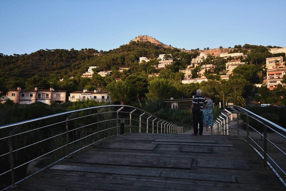 a couple of people that are standing on a bridge