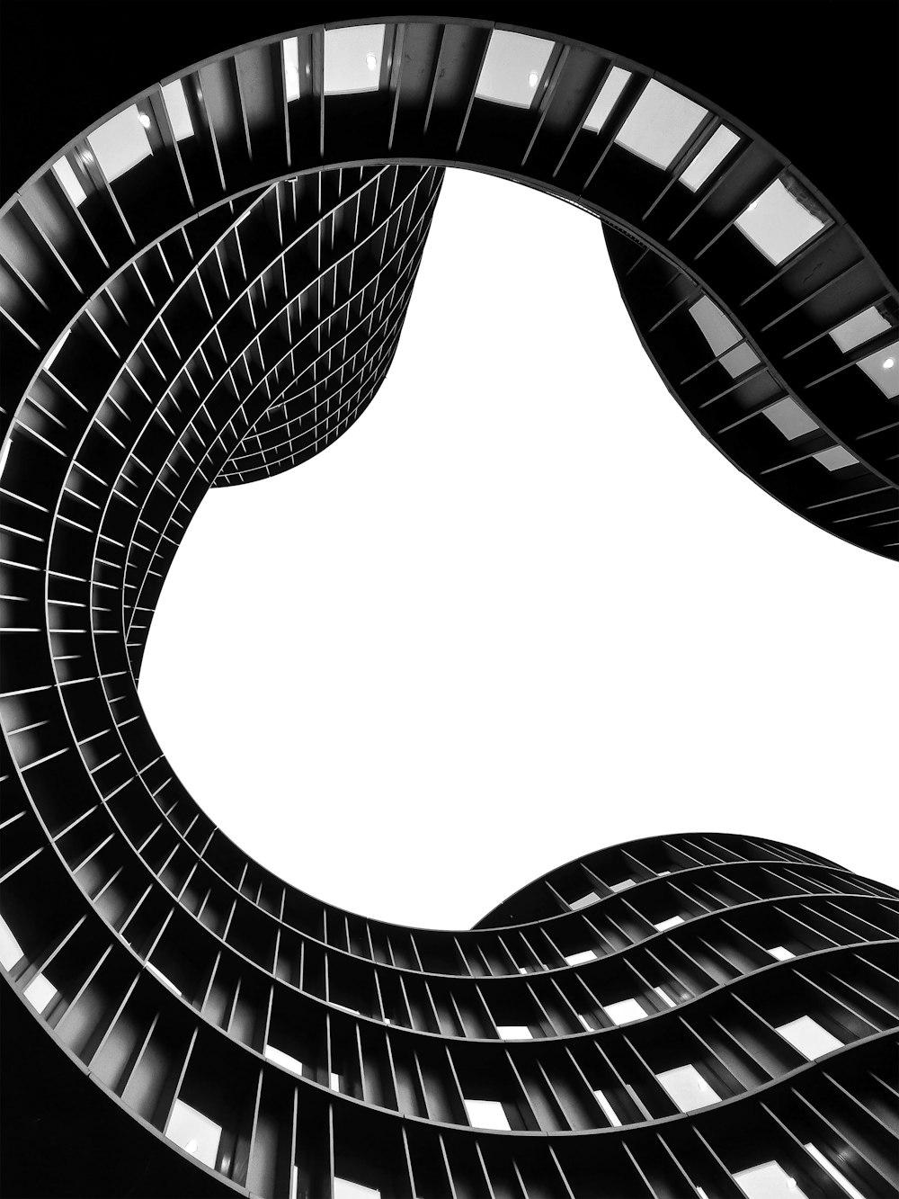 a black and white photo of a spiral shaped building