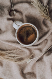 Artisan ceramic mugs filled with steaming coffee on a colorful woven Mexican textile