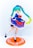 A figure of an anime character with teal twin-tails and bright green eyes, dressed in a navy blue dress adorned with red flowers and a red bow. The character stands on one leg with the other slightly raised, showcasing white socks and black shoes. The dress has white frilled hem and the figure is mounted on an orange circular base with white decorative patterns.
