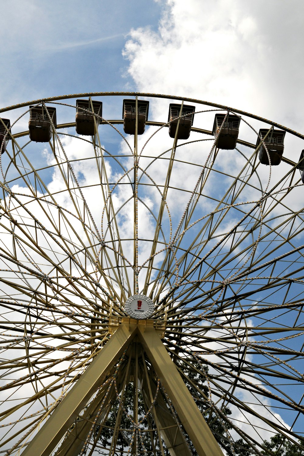 a large ferris wheel sitting under a cloudy blue sky