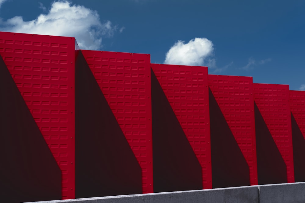 a row of red brick wall with a blue sky in the background