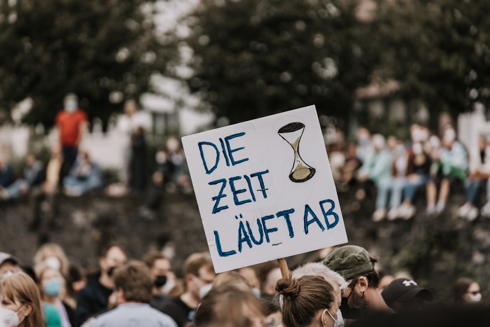 a protest with a sign that says die zeit lauftab