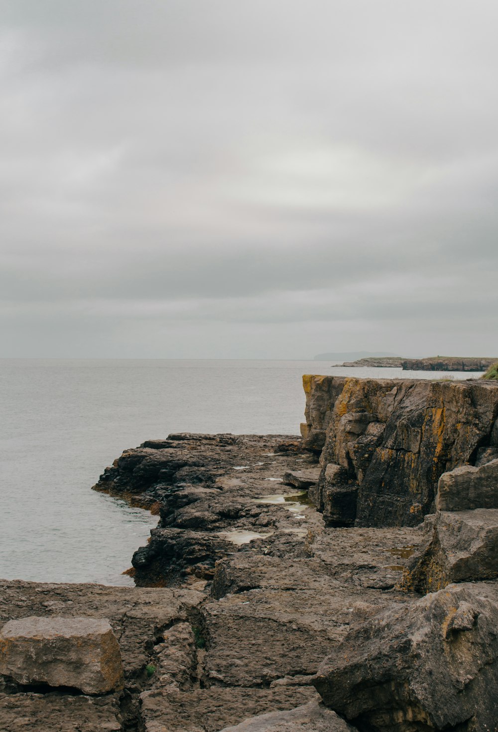 a person standing on a rocky cliff near the ocean