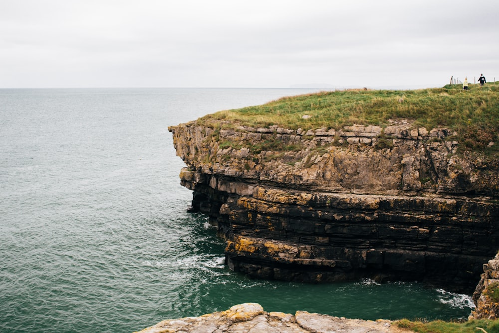 a cliff with a grassy area on top of it