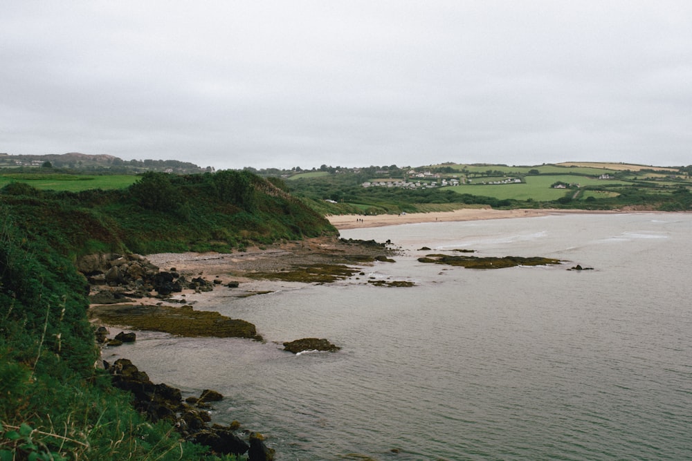 a body of water surrounded by a lush green hillside