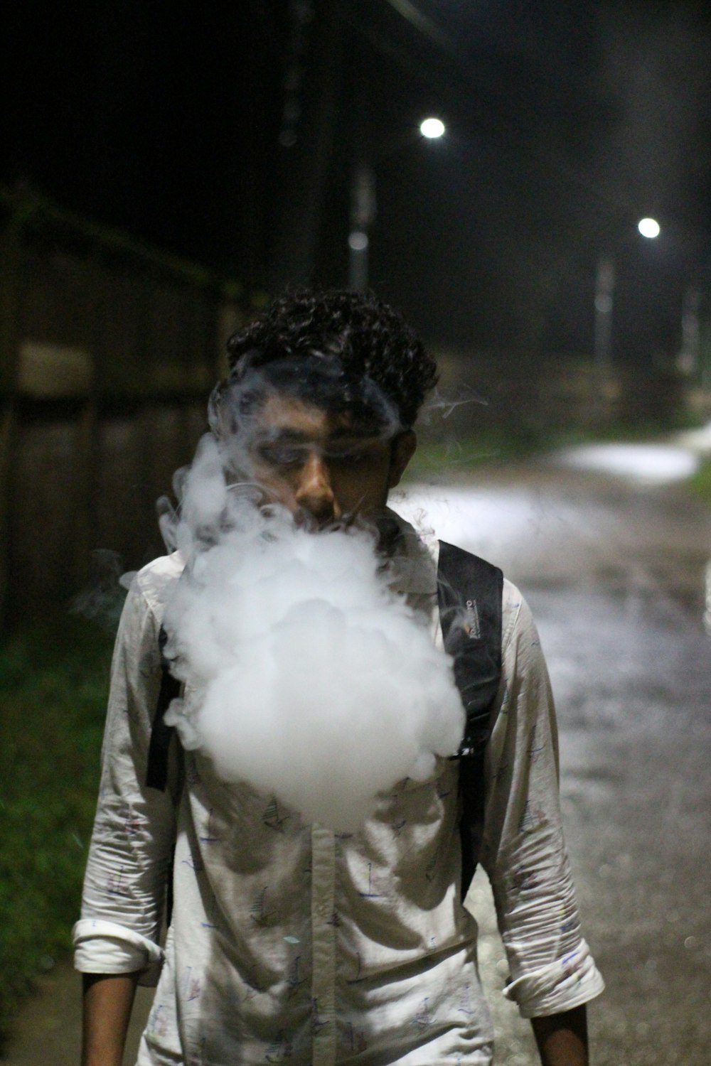 a man walking down a street with a cloud of smoke coming out of his mouth