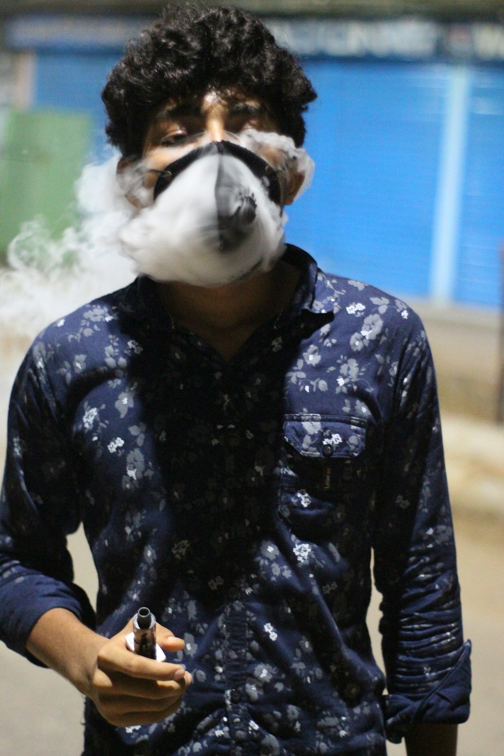 a man smoking a cigarette and wearing a mask