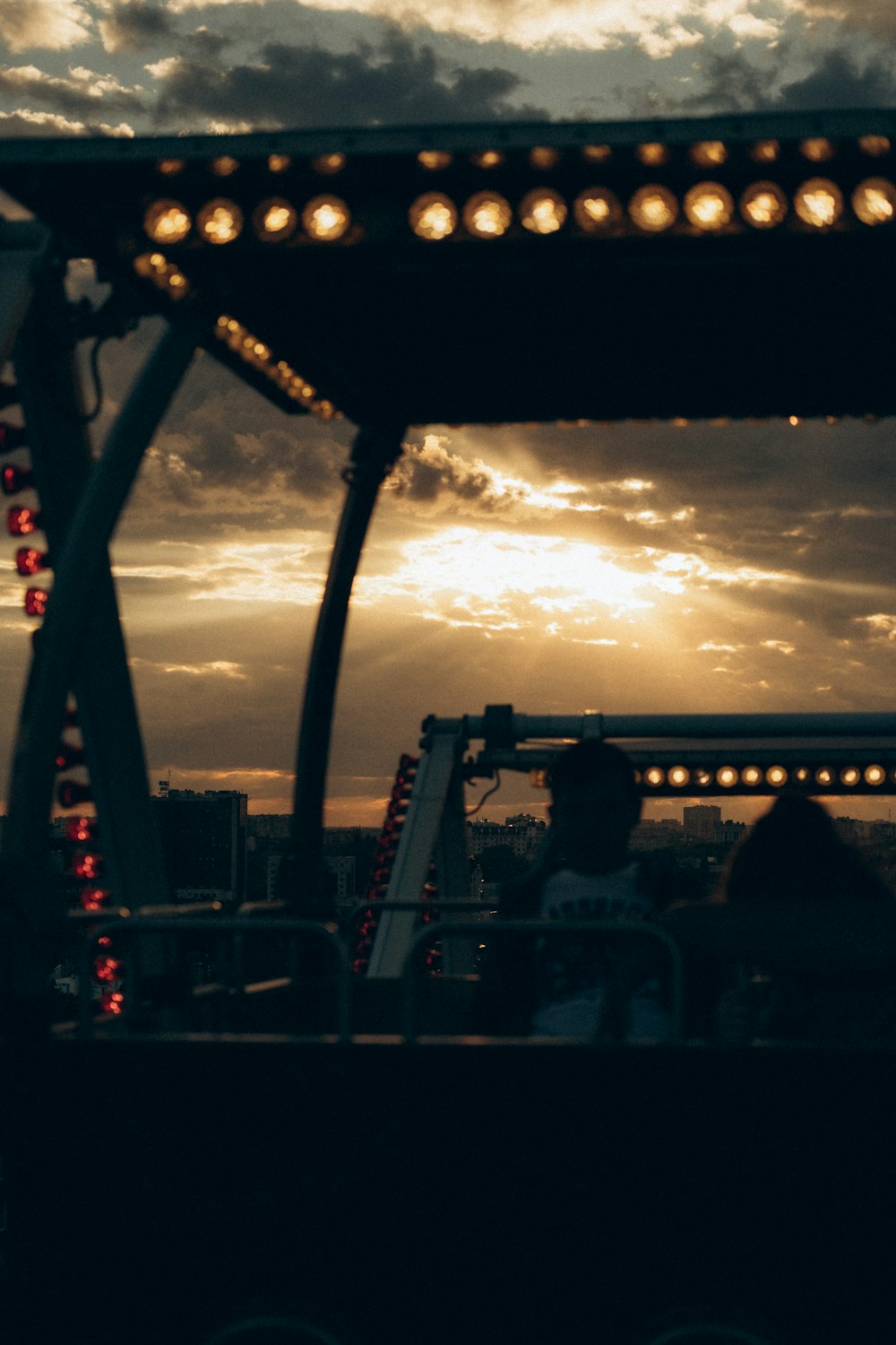 the sun is setting over a carnival ride