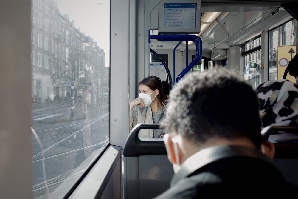 um homem e uma mulher em um ônibus olhando pela janela