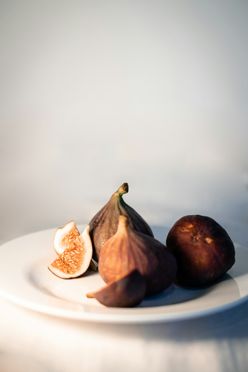 a white plate topped with figs on top of a table