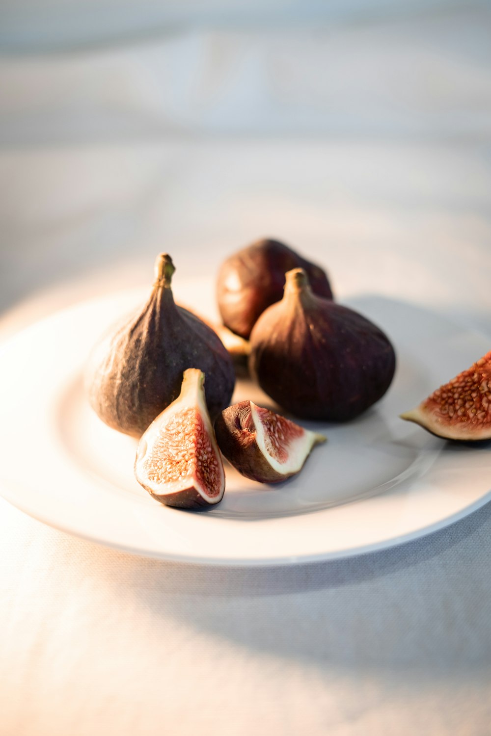 a white plate topped with figs on top of a table