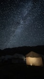 a group of tents under a night sky filled with stars