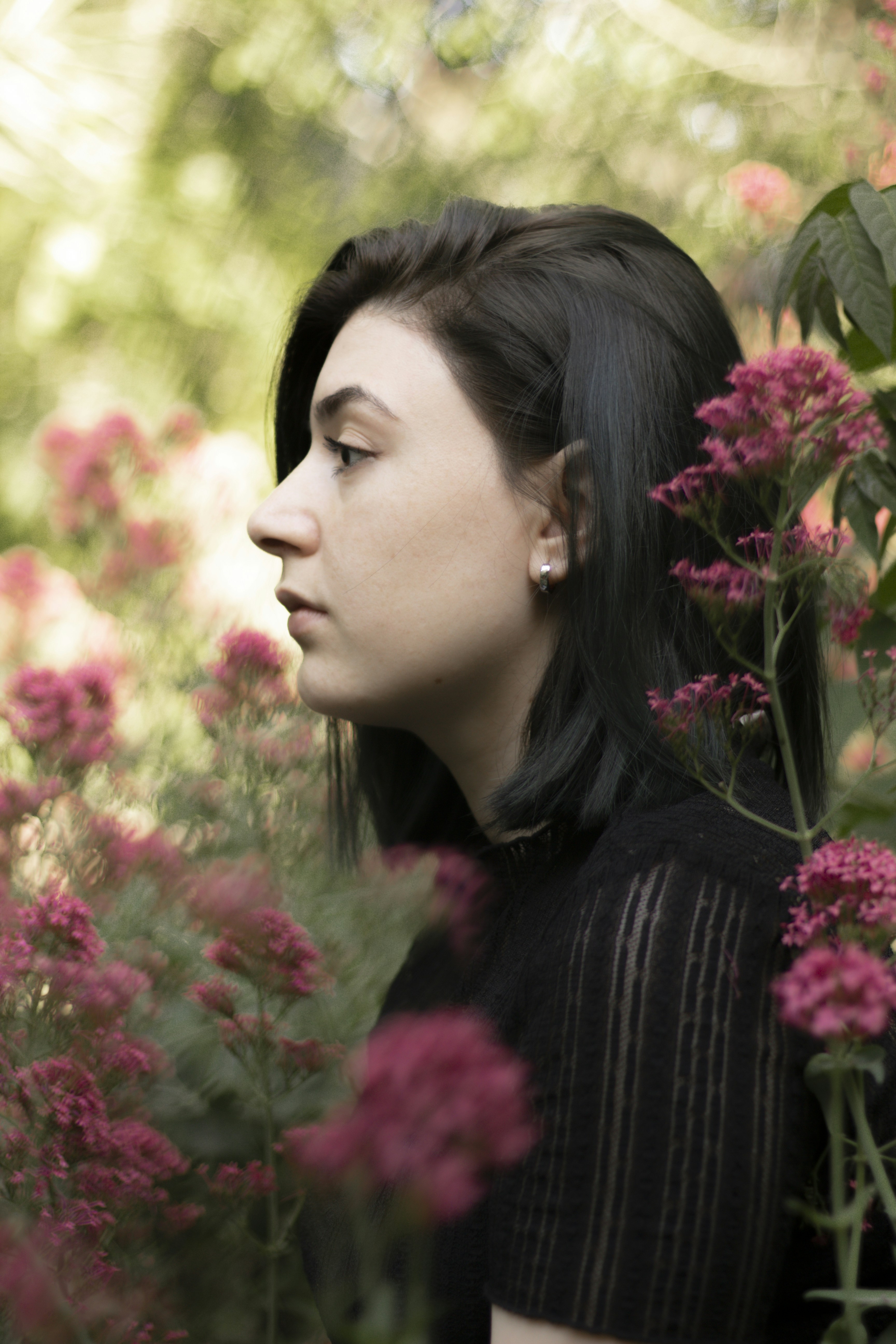 A young woman with dark hair in a garden