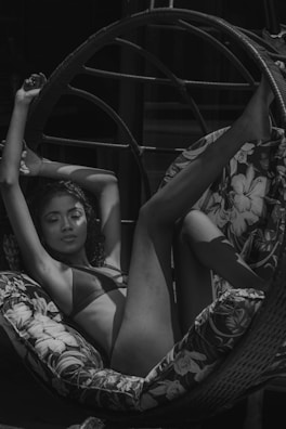 A relaxed model lounging on a white beach towel, showcasing the elegant swimwear design.