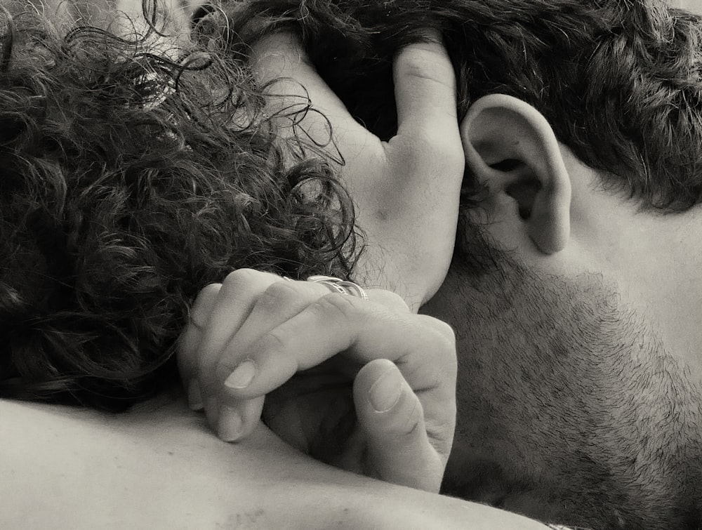 a black and white photo of a man with curly hair covering his face