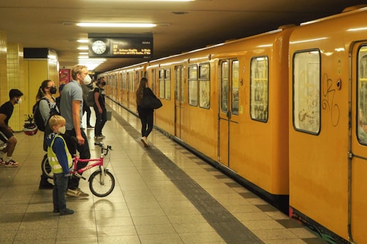 a group of people standing next to a yellow train
