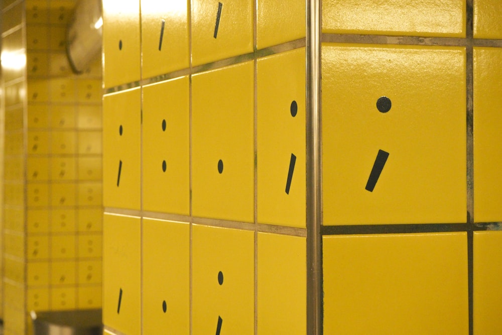 a row of yellow lockers with faces drawn on them