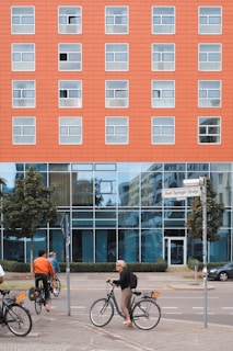 A lively urban scene in Germany with modern architecture and people cycling on the streets.