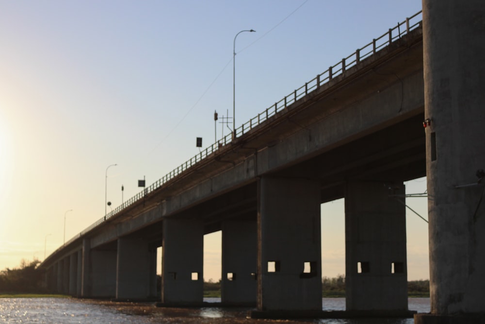 a bridge over a body of water at sunset