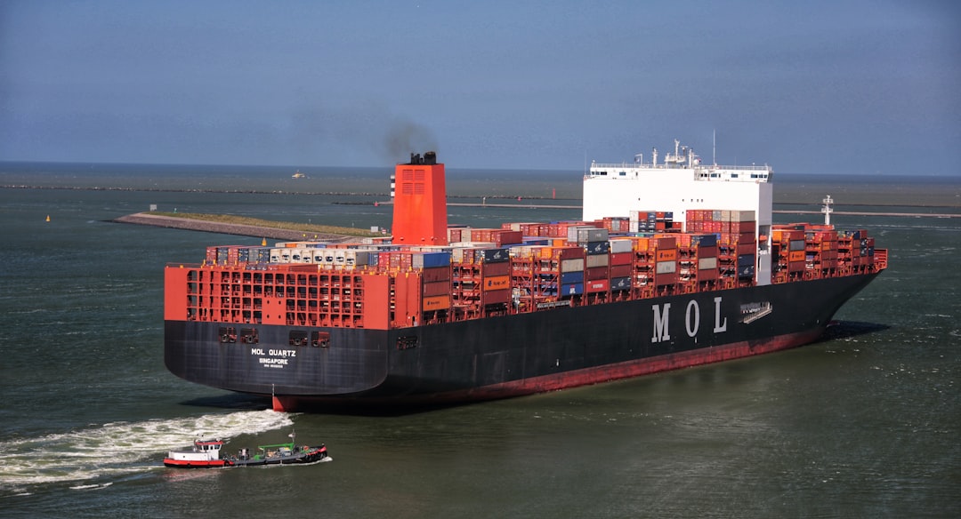 a large cargo ship sailing in the ocean, Container vessel leaving the port of Rotterdam