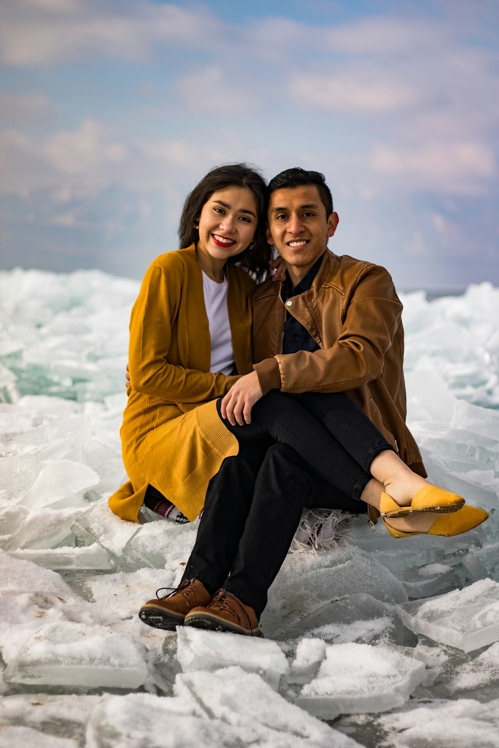 a man and a woman sitting on ice