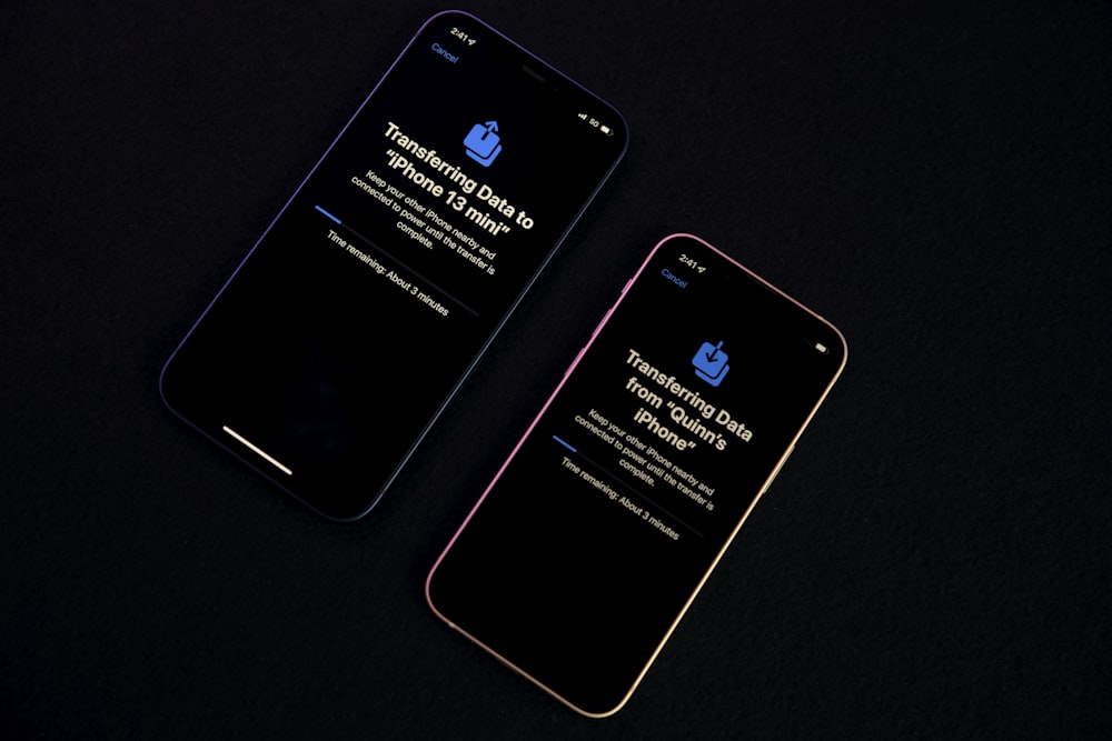 dois iphones sentados um ao lado do outro em uma mesa