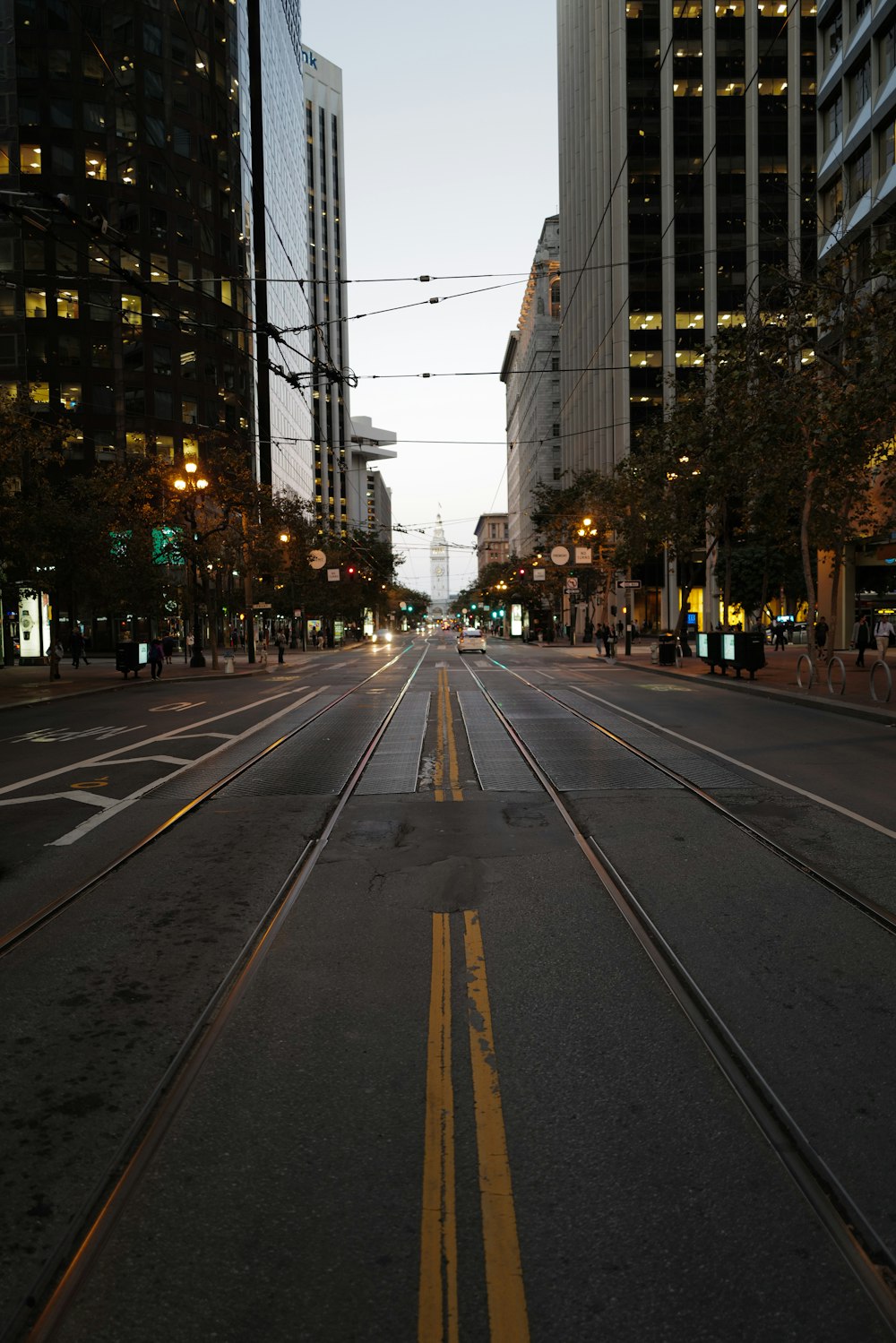 a city street with a train track going down the middle of it