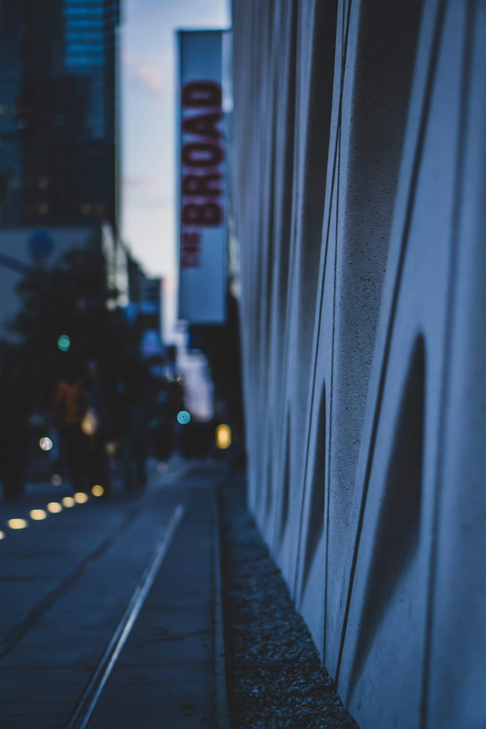 a person walking down a street next to a tall building