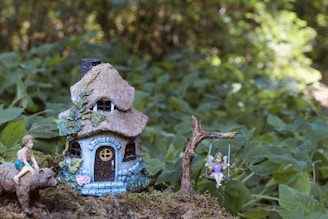 a fairy garden with a little house and a pig