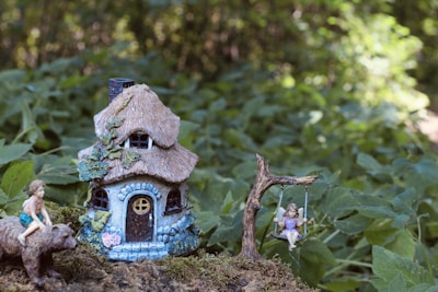 a fairy garden with a little house and a pig