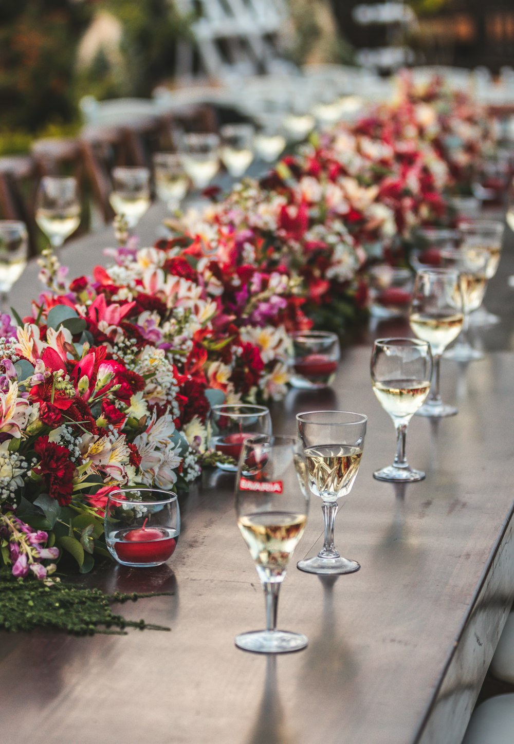 a row of wine glasses sitting on top of a wooden table