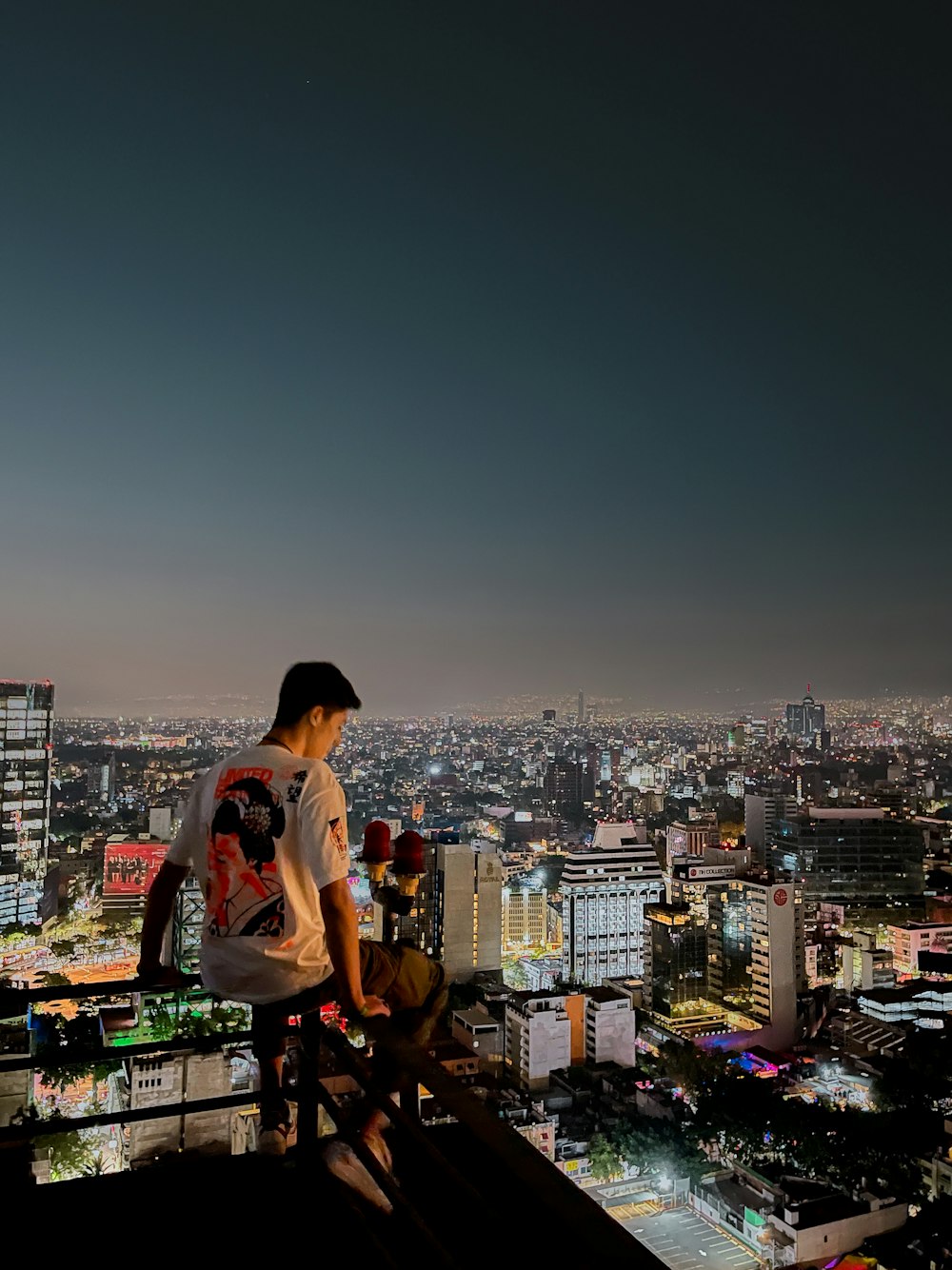 a man sitting on top of a tall building