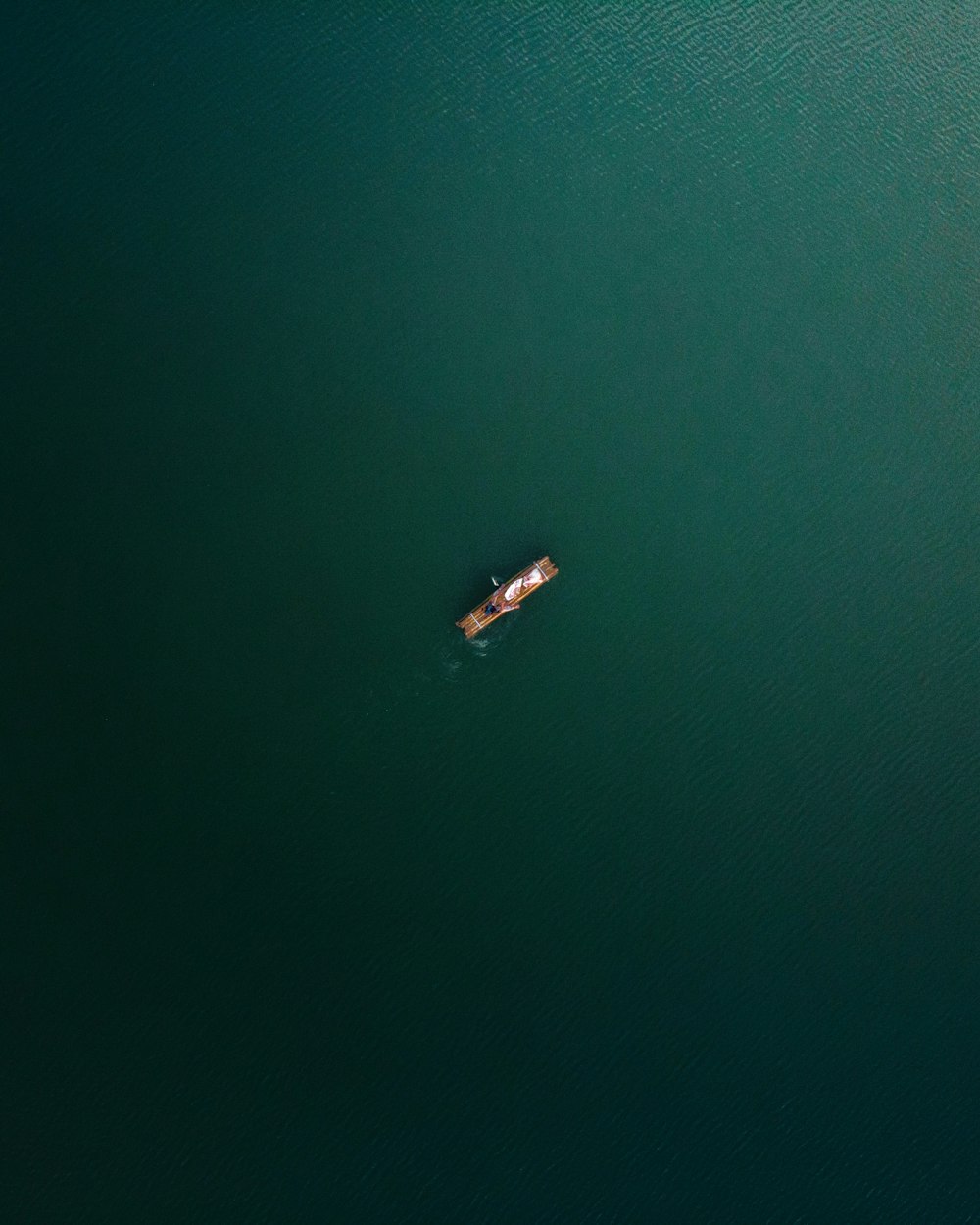 a small boat floating on top of a large body of water