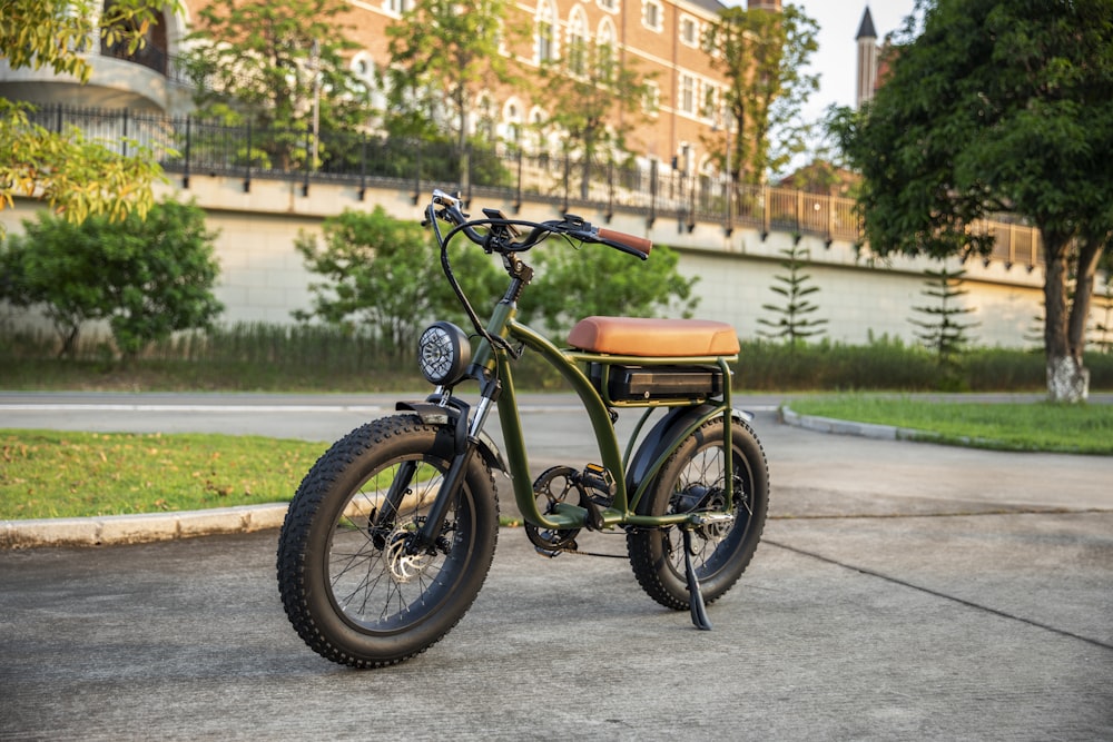 a green bike with a brown seat parked in a parking lot