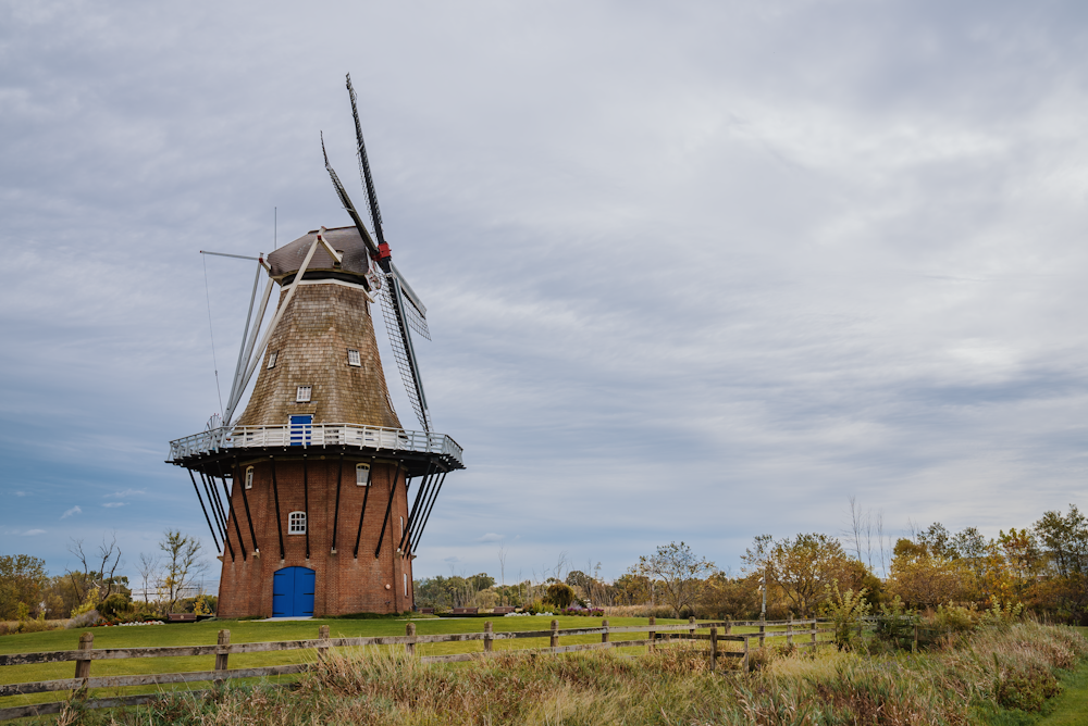 a windmill sitting on top of a lush green field