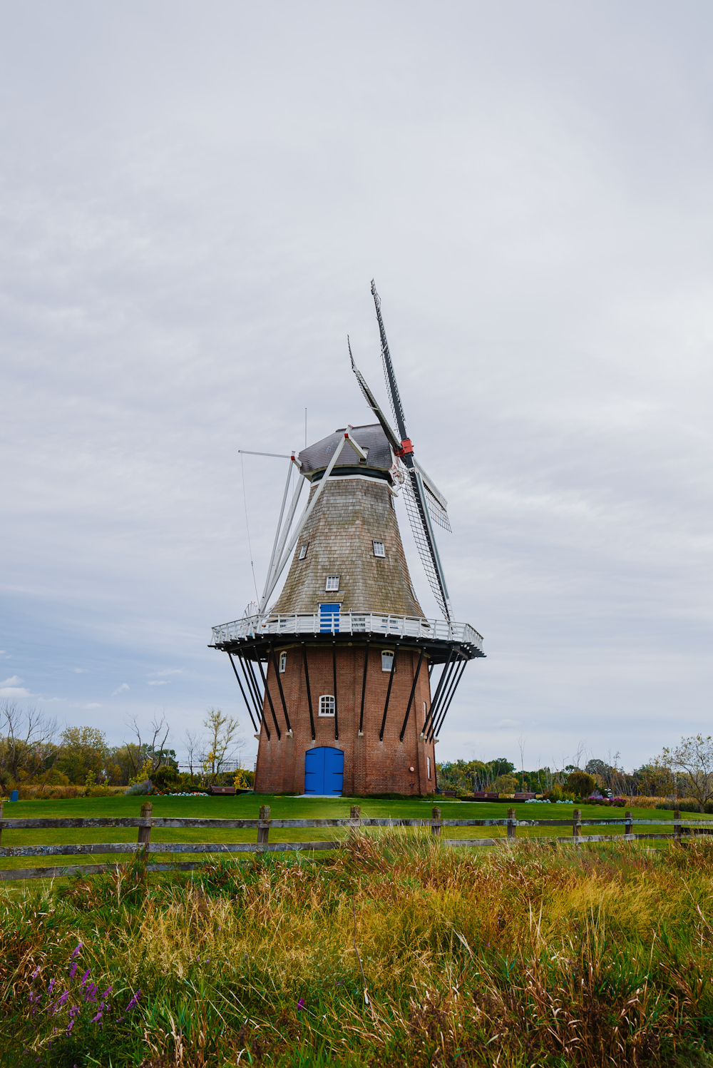 a windmill sitting on top of a lush green field