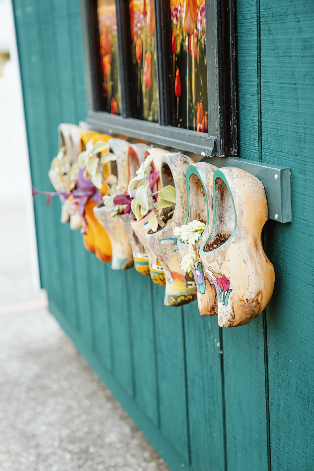 a row of wooden masks hanging on a green wall